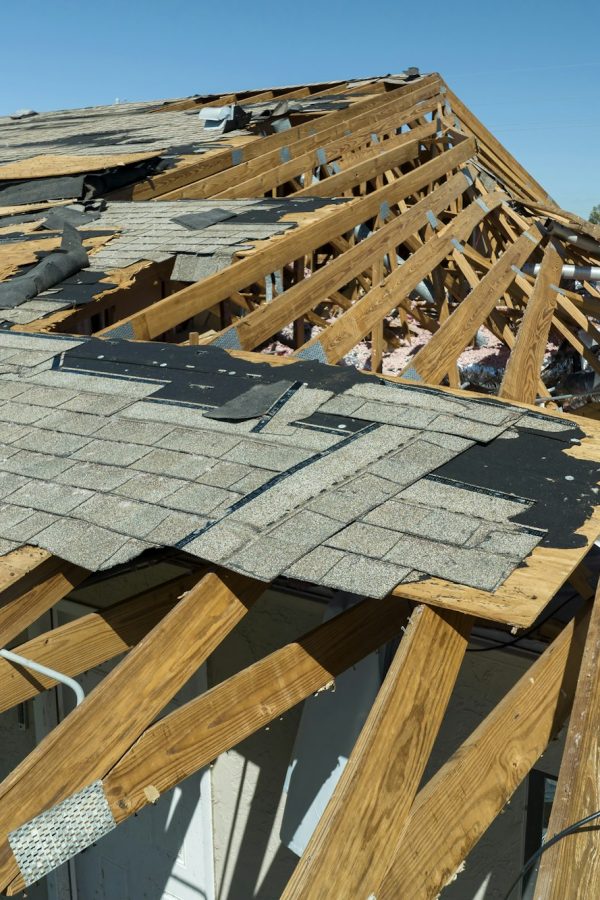 Damaged house roof with missing shingles after hurricane Ian in Florida.